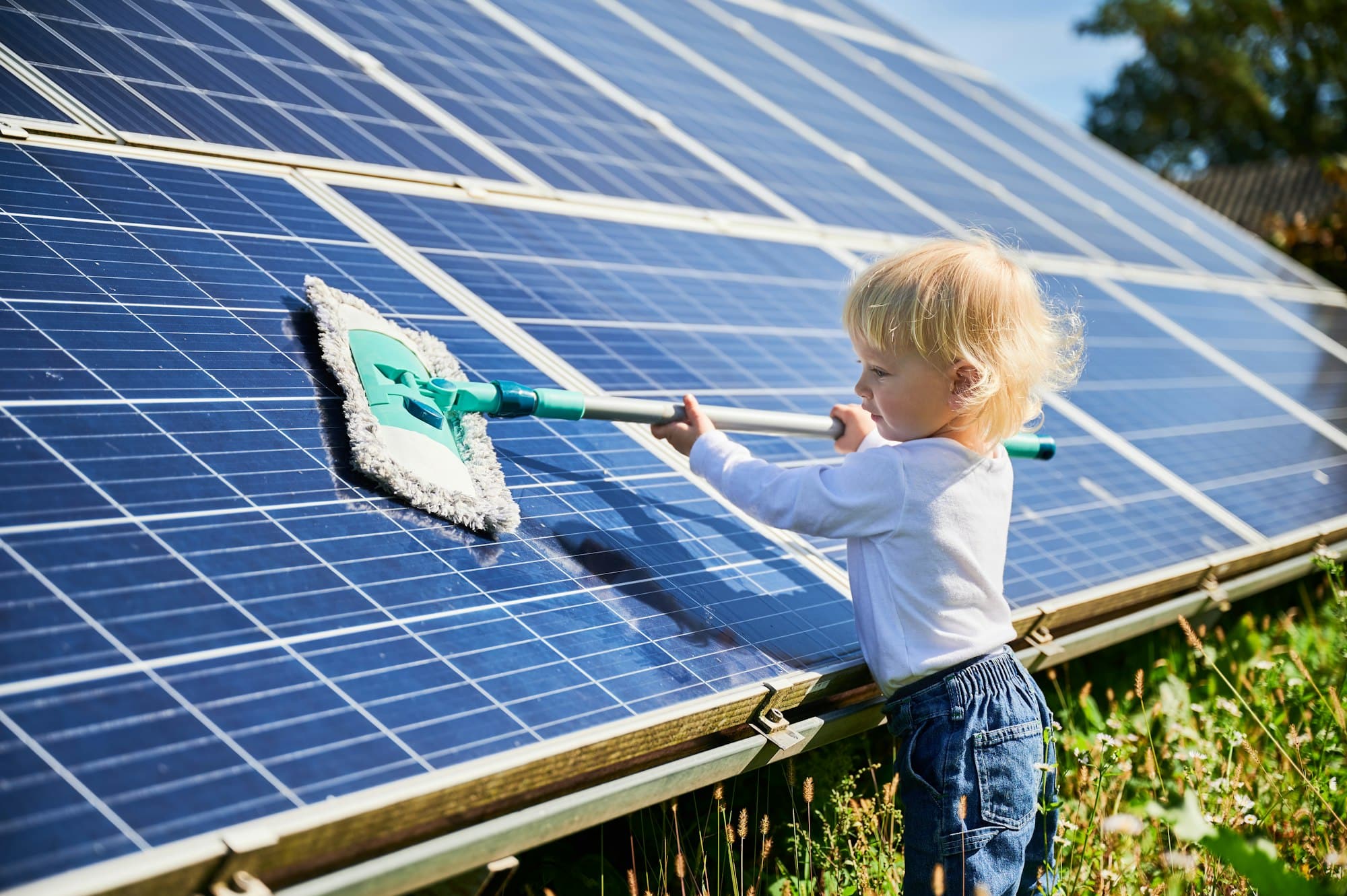 Klein kind dat zonnepanelen schoonmaakt - Hoe maak je zonnepanelen schoon | Asenso Schoonmaakdiensten