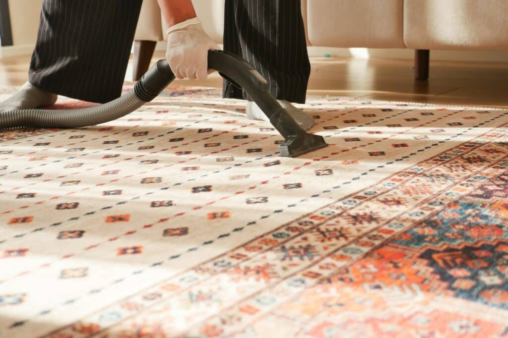 Schoonmaker die tapijt stofzuigt - Hoe tapijt schoonmaken | Asenso Schoonmaakdiensten