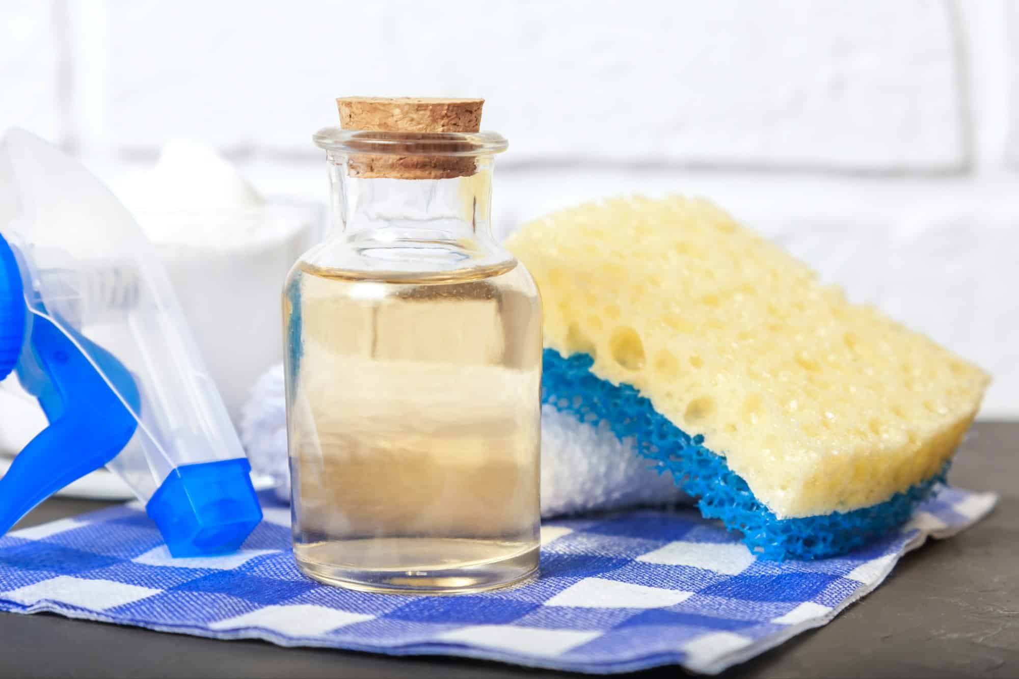 Schoonmaak azijn in glazen fles met spons | Wat mag je niet schoonmaken met schoonmaakazijn | Asenso Schoonmaakdiensten