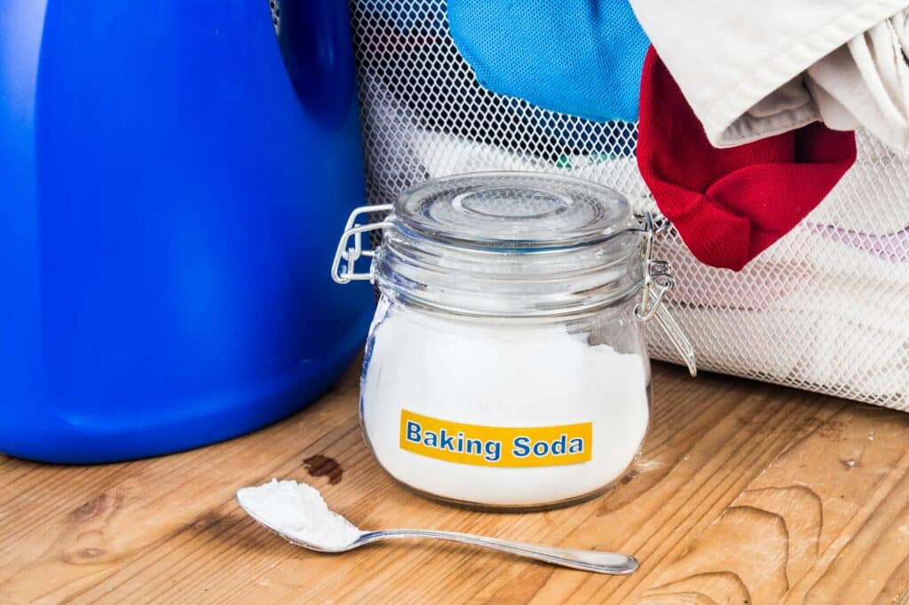 Baking soda met wasmiddel en een stapel vuile was | Wat niet schoonmaken met baking soda | Asenso Schoonmaakdiensten