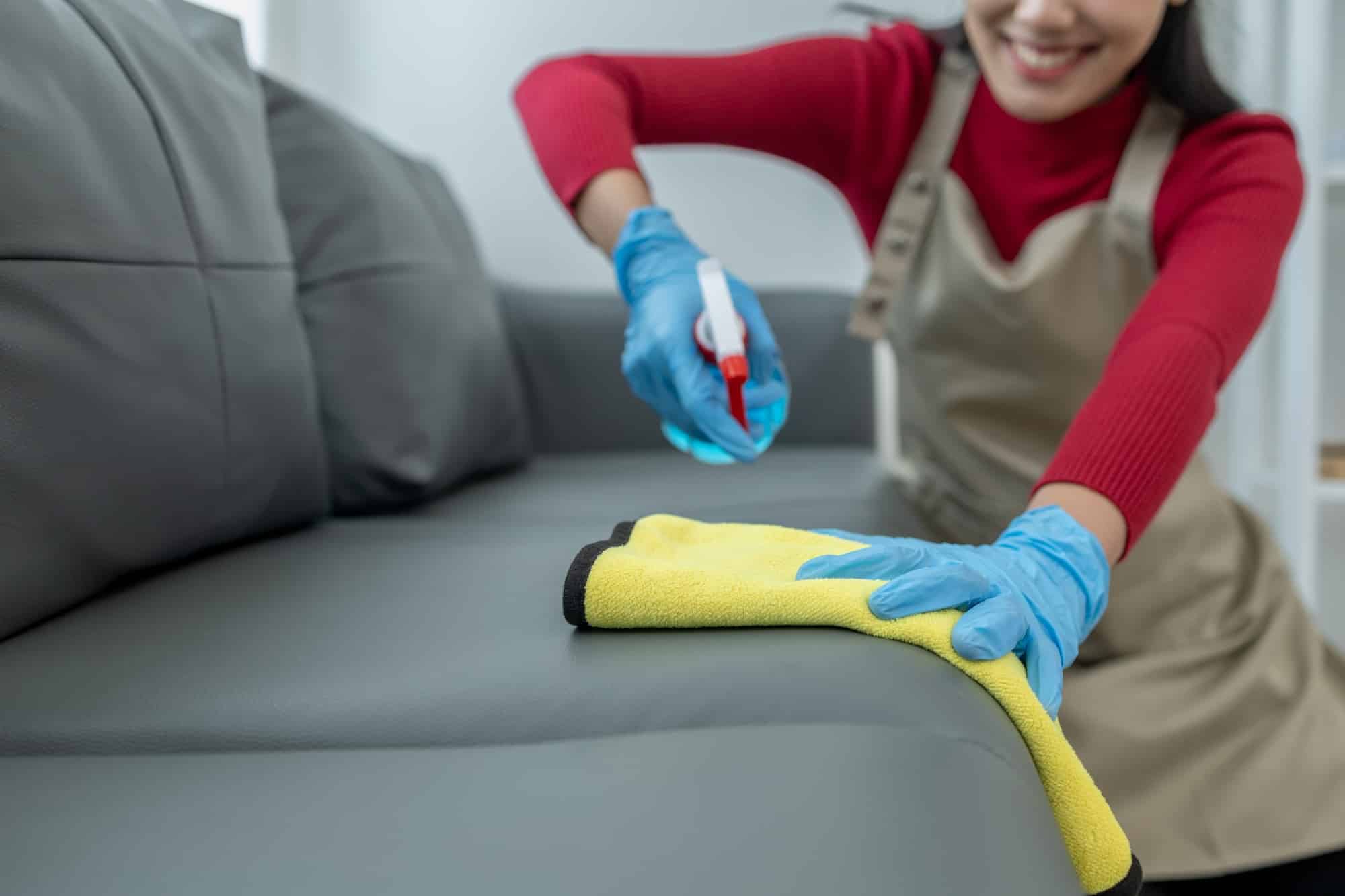 Vrouw die leren bank schoonmaakt | hoe bank schoonmaken | Asenso Schoonmaakdiensten