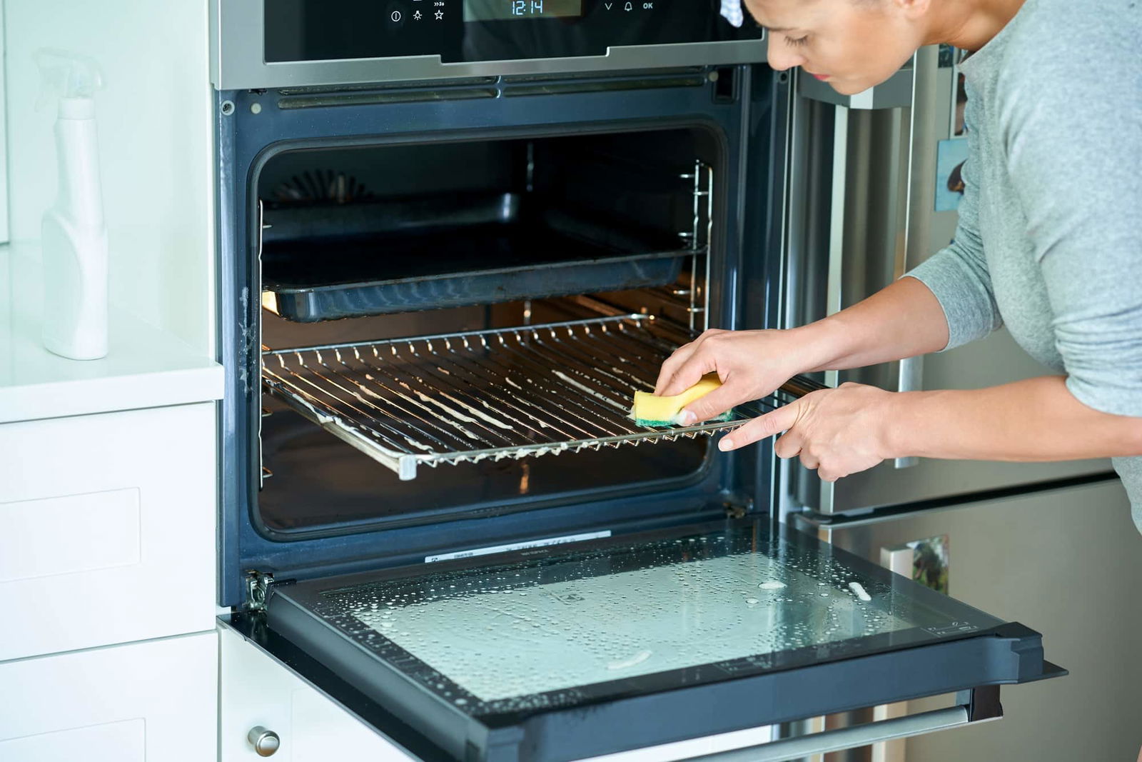 Vrouw die oven schoonmaakt | Hoe oven schoonmaken | Asenso Schoonmaakdiensten