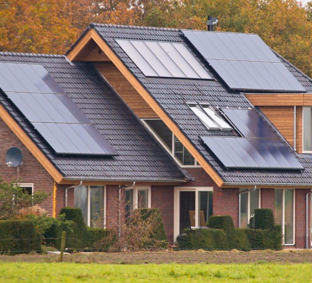 Zonnepanelen op een huis | Hoe zonnepanelen schoonmaken met tuinslang | Asenso Schoonmaakdiensten