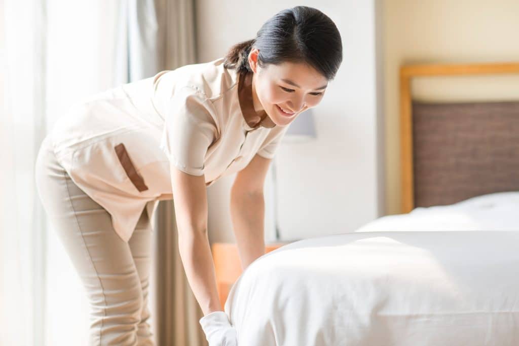 Vrouw die bed opmaakt | Hoe matras schoonmaken | Asenso Schoonmaakdiensten