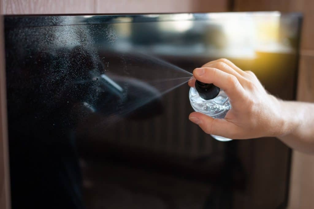 Man die TV besproeit met speciaal TV schoonmaakmiddel | Hoe TV schoonmaken | Asenso Schoonmaakdiensten