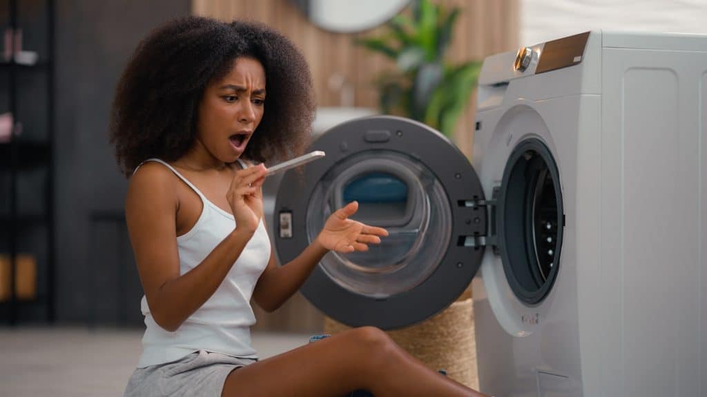 Vrouw die filter wasmachine schoonmaakt | Filter wasmachine schoonmaken | Asenso Schoonmaakdiensten