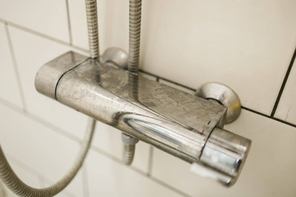 Close up van douche bediening met kalk | Kalk schoonmaken | Asenso Schoonmaakdiensten