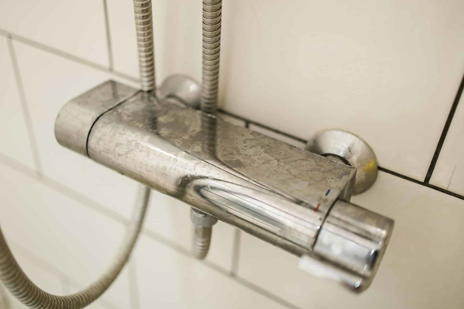 Close up van douche bediening met kalk | Kalk schoonmaken | Asenso Schoonmaakdiensten