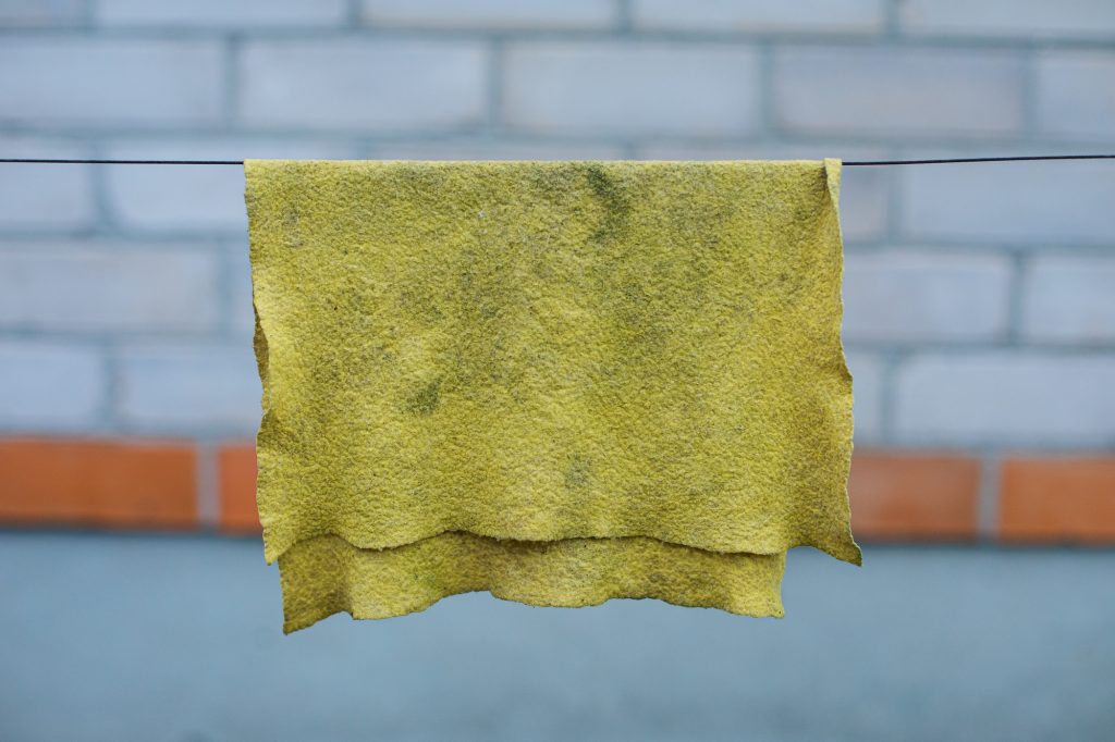 Vies geel schoonmaakdoekje dat aan de waslijn hangt | Schoonmaakdoekje vervangen | Asenso Schoonmaakdiensten