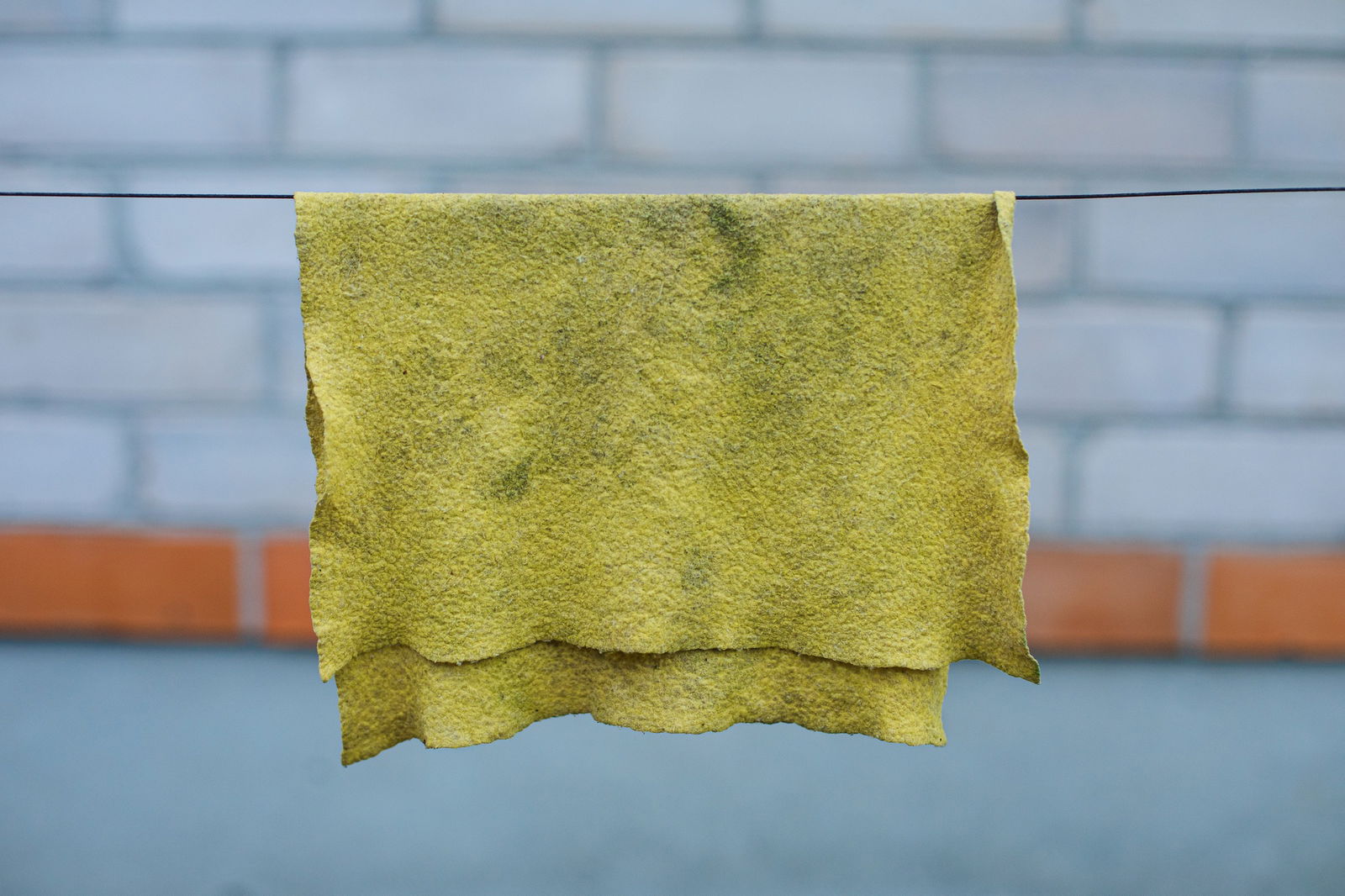 Vies geel schoonmaakdoekje dat aan de waslijn hangt | Schoonmaakdoekje vervangen | Asenso Schoonmaakdiensten