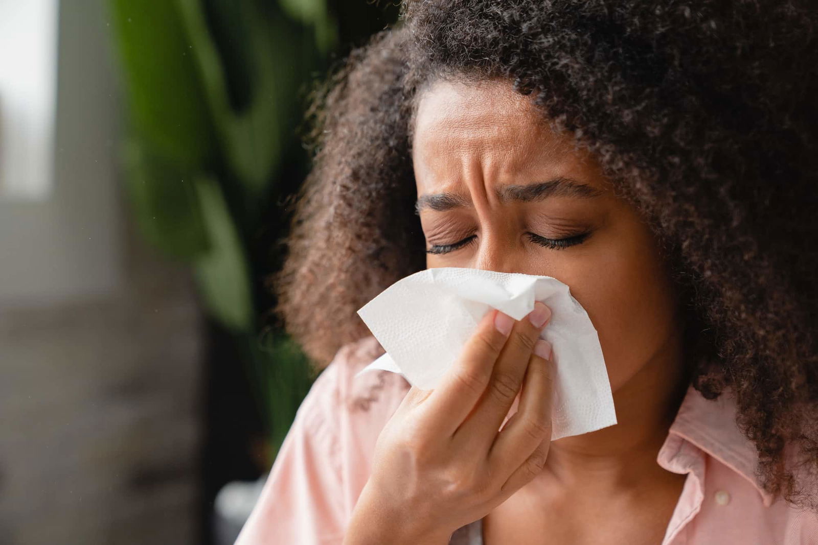 Close-up van vrouw die haar neus snuit | Schoonmaken allergie | Asenso Schoonmaakdiensten