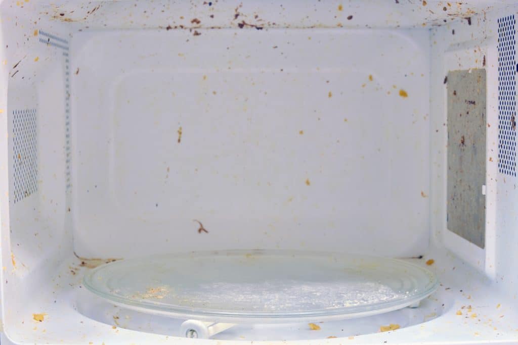 Close-up van een vieze magnetron vanbinnen | Magnetron schoonmaken | Asenso Schoonmaakdiensten