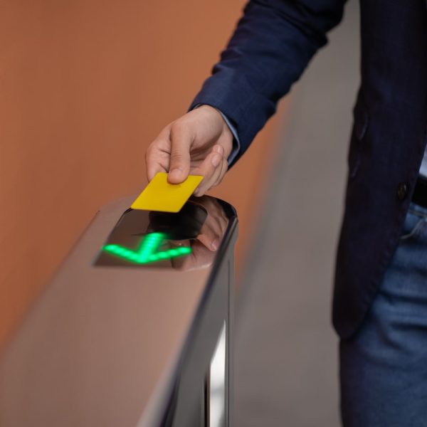 Unrecognizable man in formal outfit holding Electronic entrance gate card, cropped of worker passing access building security system at office, panorama with copy space, closeup